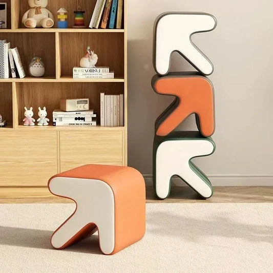 Modern orange and white chair and stool in a room with a bookshelf.
