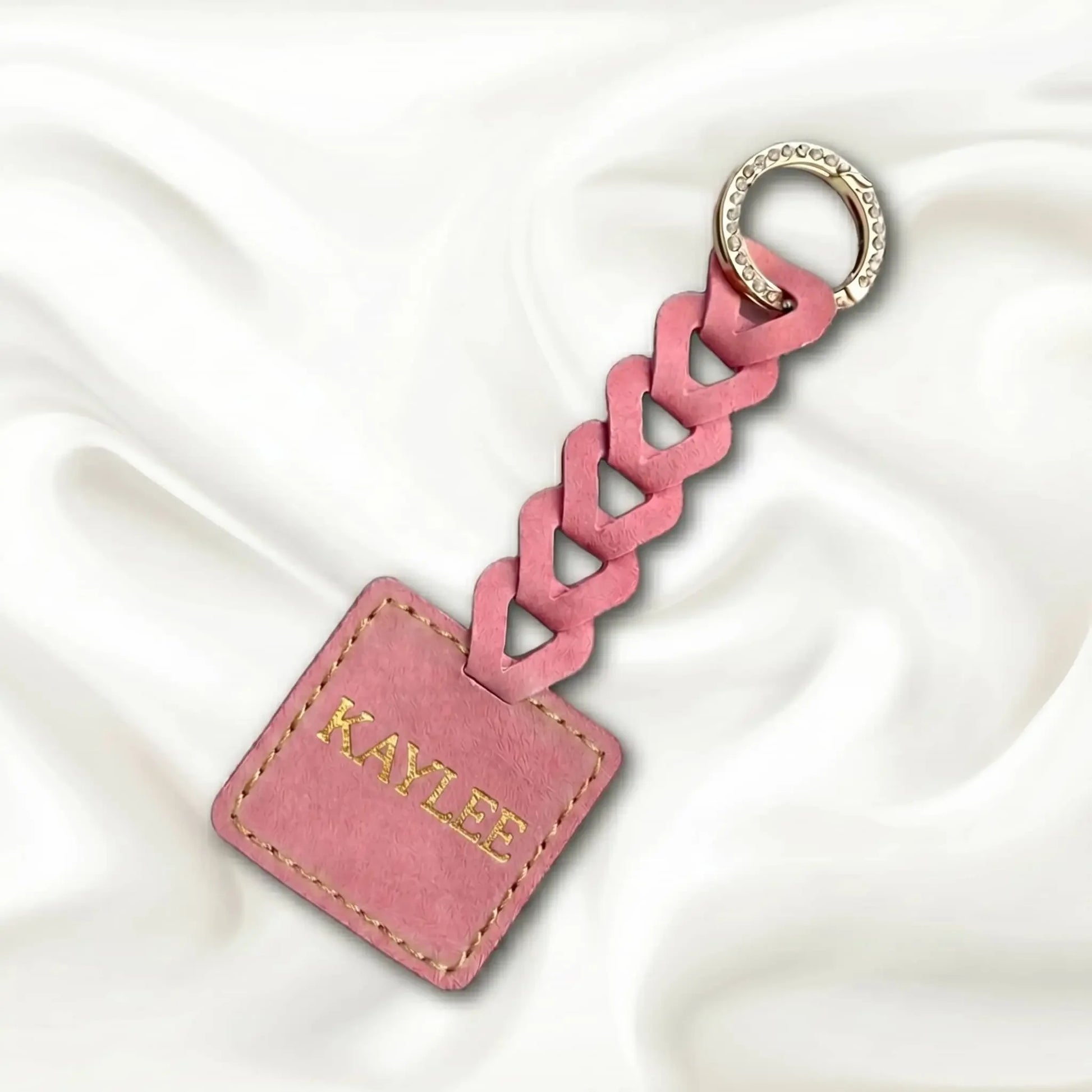 Pink braided keychain with a tag on a white background