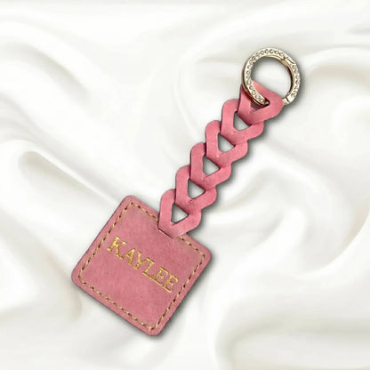 Pink braided keychain with a tag on a white background
