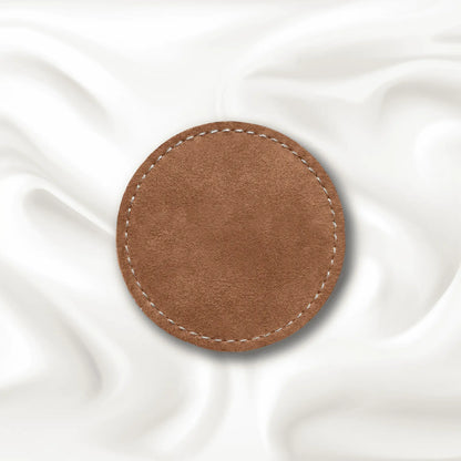 Brown circular leather patch on a white fabric background