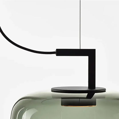 Modern pendant light with black fixture and glass shade on a white background
