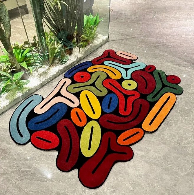 Colorful abstract rug on a concrete floor with plants in the background