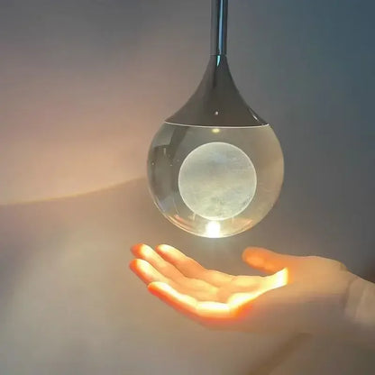 Clear glass orb held in a hand with a soft gradient background