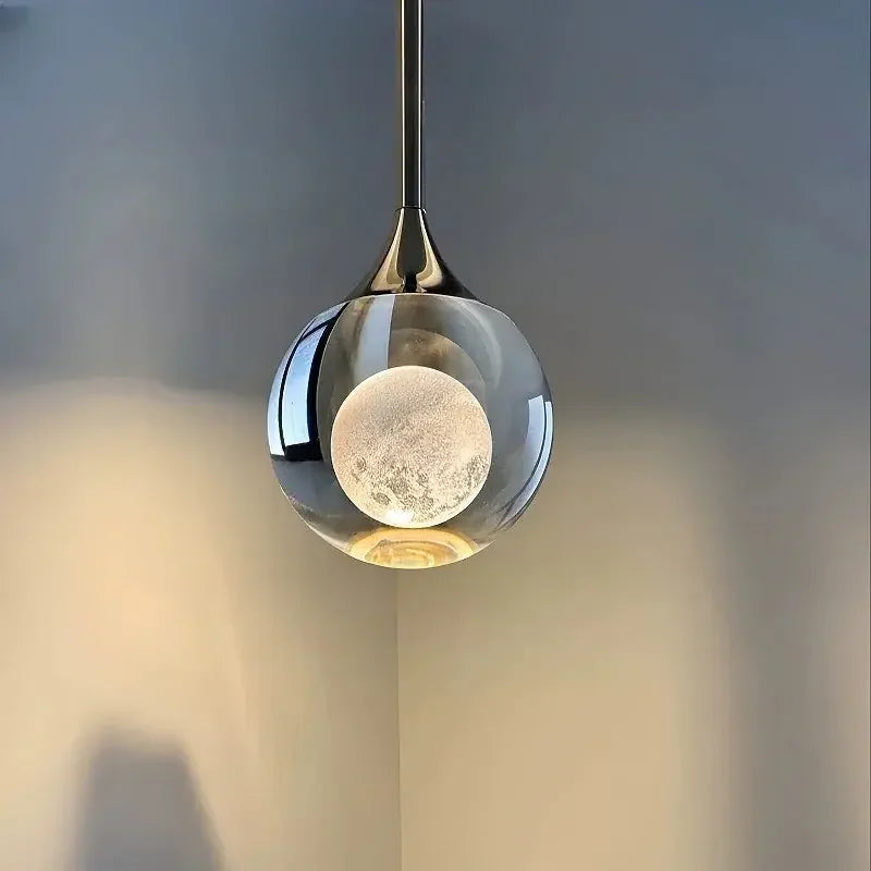 Modern Art Moon Pendant with a glass shade against a neutral background