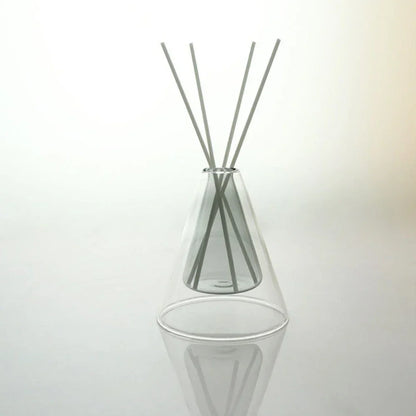 Clear glass diffuser with reeds on a white background