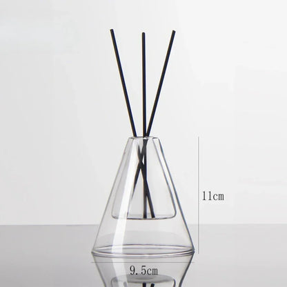 Clear glass diffuser with black sticks on a white background