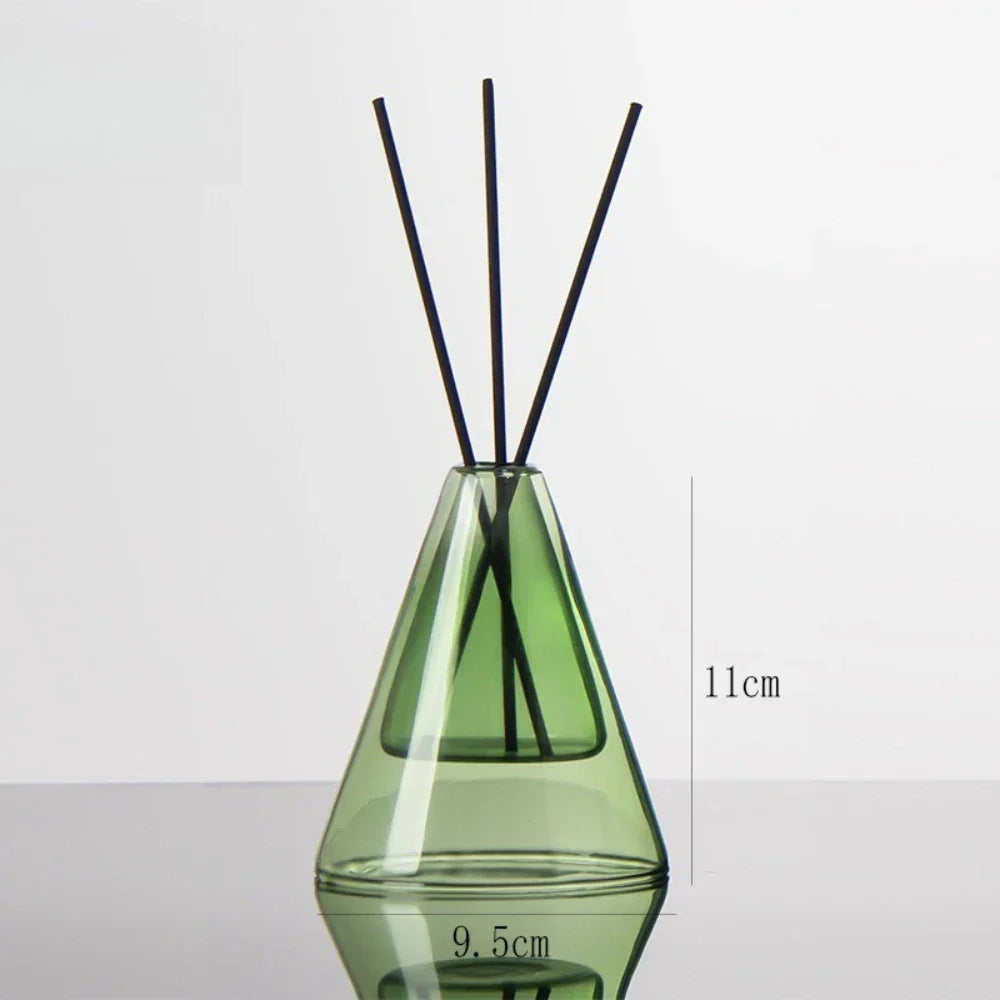 Green diffuser bottle with black sticks on a white background