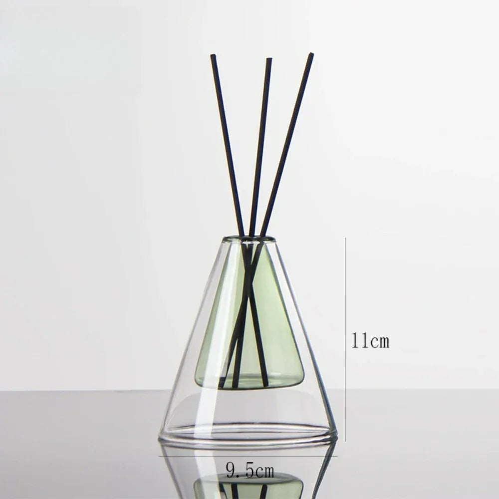 Clear glass diffuser with black sticks inside on a white background