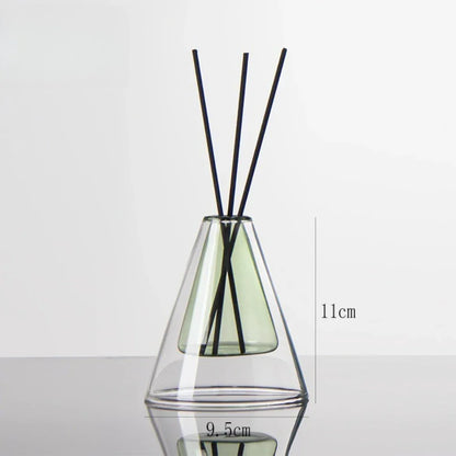 Clear glass diffuser with black sticks inside on a white background