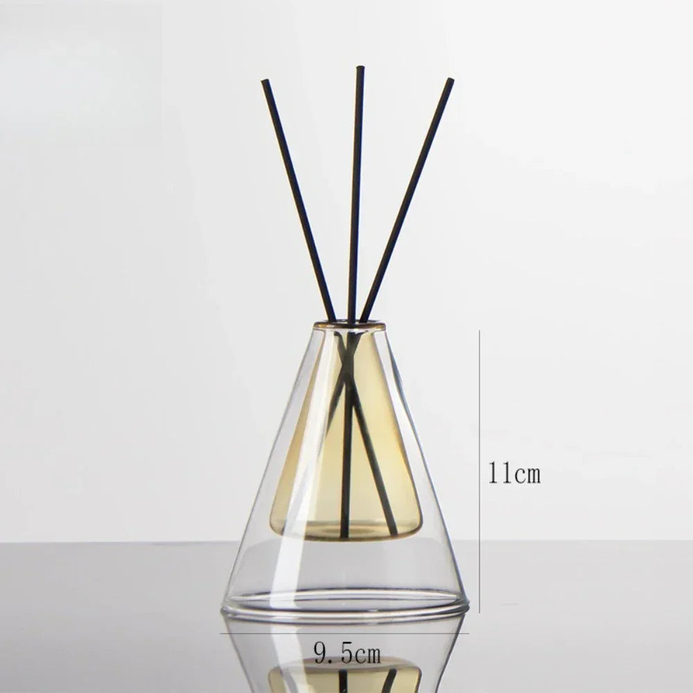 Clear glass diffuser with black sticks inside on a white background